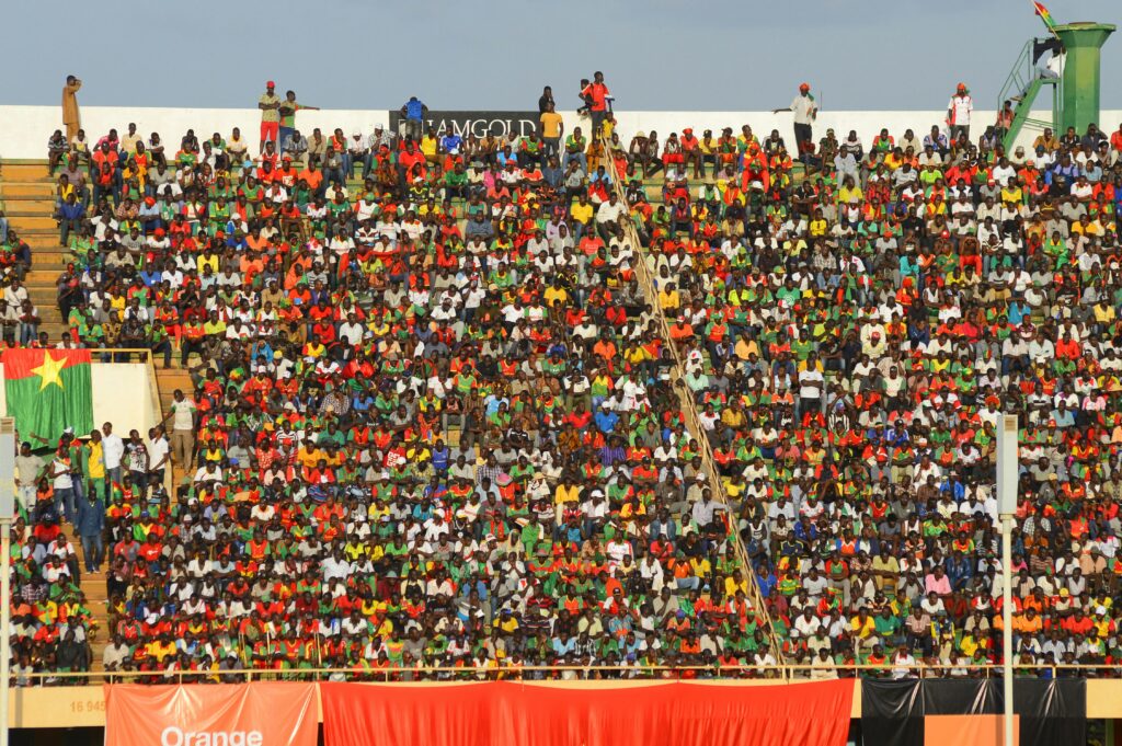 Vibrant crowd of soccer fans fills stadium seats during an exciting football match.